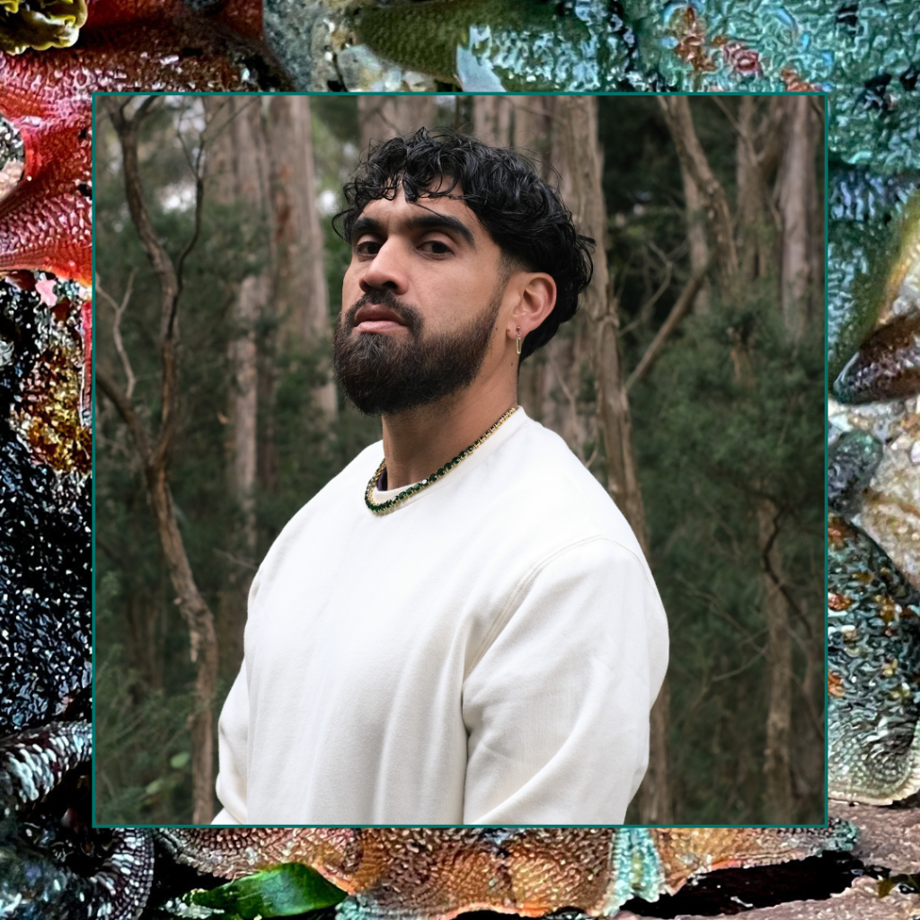 Omar Musa standing in a forest, wearing a white top and beaded necklace. Image by Quinn Ryder