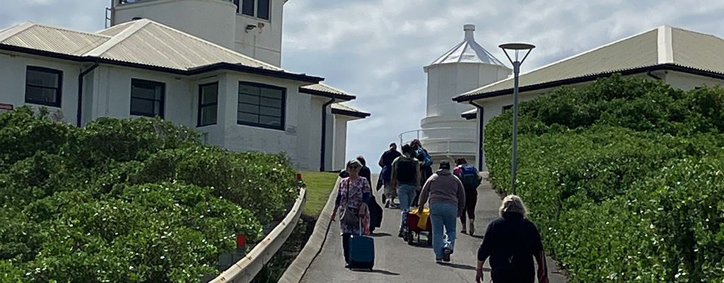 A photo of people walking up Whibayganba- Nobbys headland